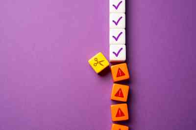 Reihe aus Würfeln wird mit Schere durchtrennt