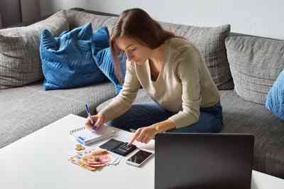 Frau mit Taschenrechner und Bargeld